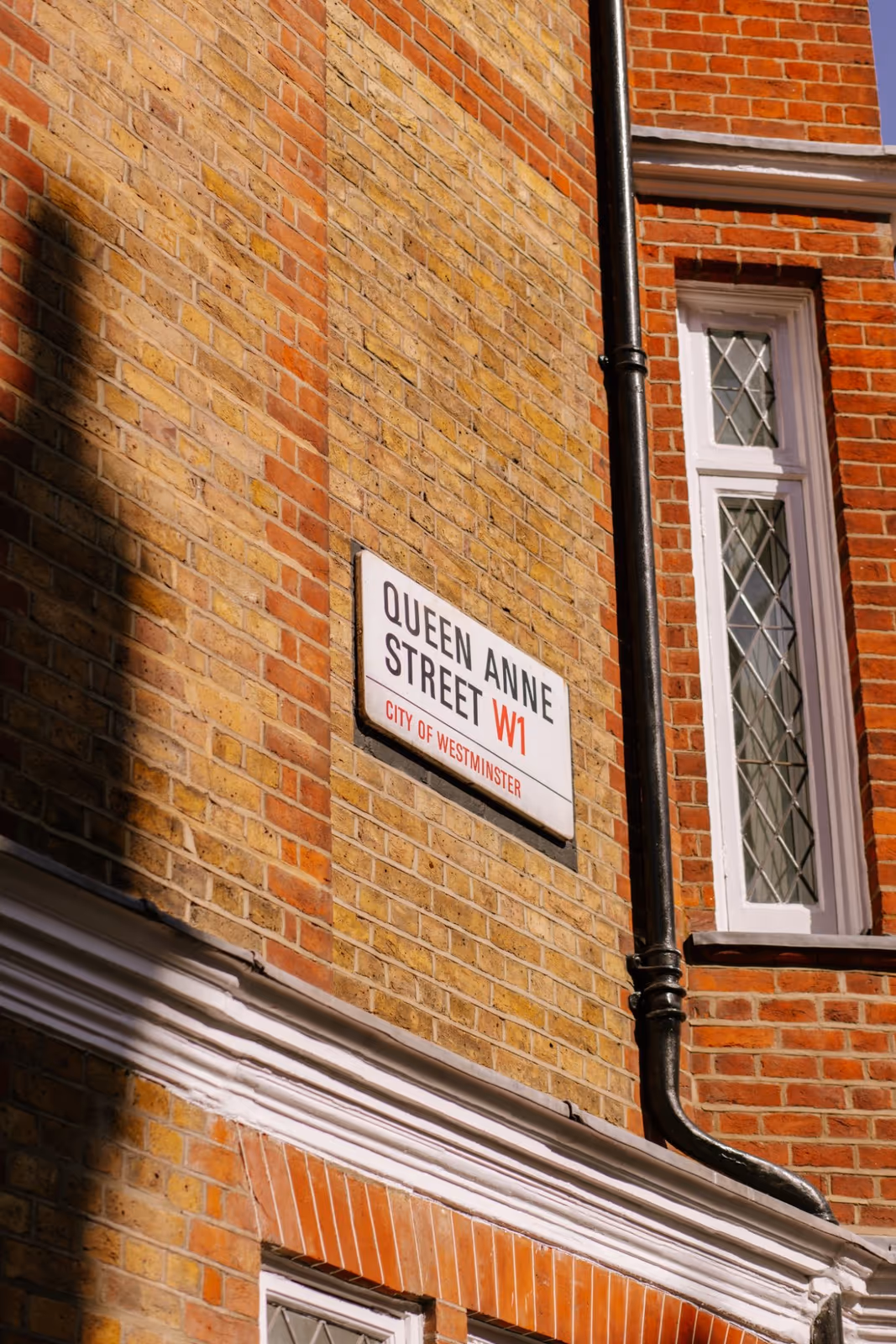 The Queen Anne Street W1 sign on the brickwork outside the centre